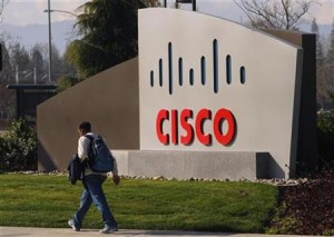 A pedestrian walks past the Cisco logo at the technology company's campus in San Jose