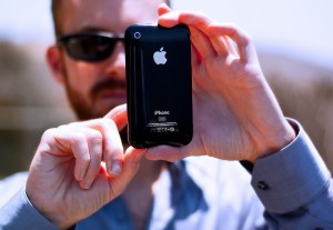 man holding iphone using iphone logo back apple