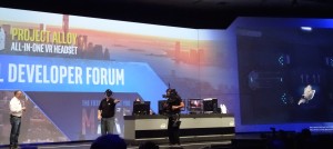 Intel CEO Brian Krzanich helps demonstrate the Project Alloy VR headset, showing the wearer's own hands on the screen at right.